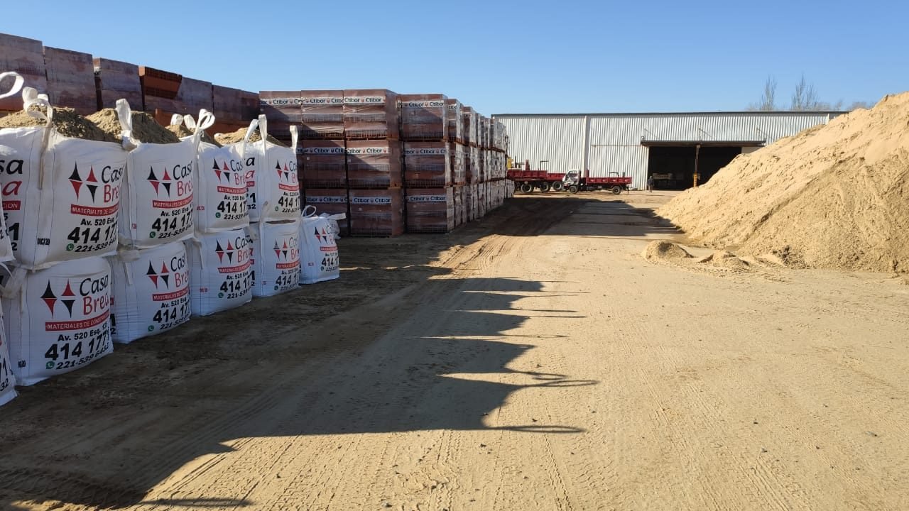 Bolsones de arena, pallets de ladrillo y arena a granel en el predio de Casa Brea.